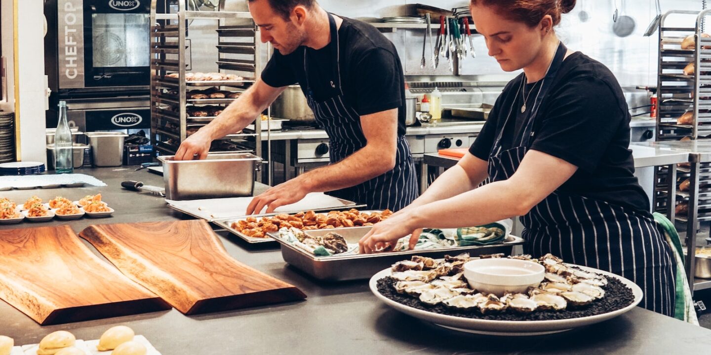 Man and Woman Wearing Black and White Striped Aprons Cooking