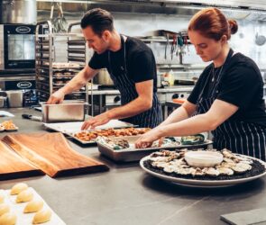 Man and Woman Wearing Black and White Striped Aprons Cooking