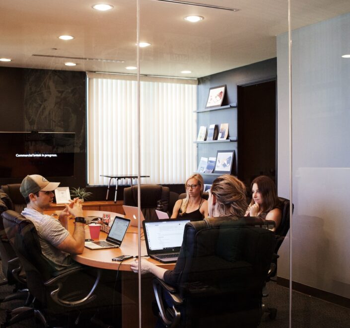 people sitting near table with laptop computer