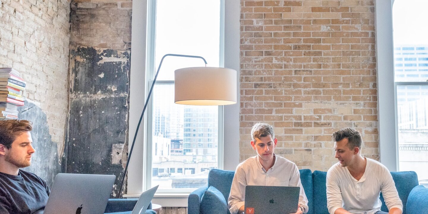 three men using MacBooks